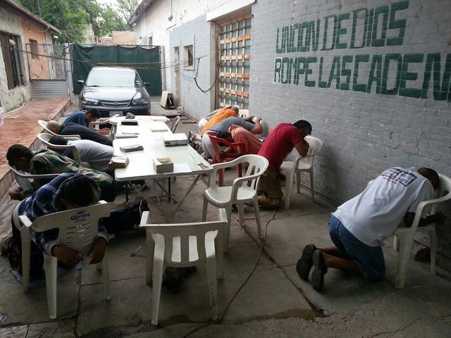 Hombres de la casa de rescate orando por el pueblo de Dios